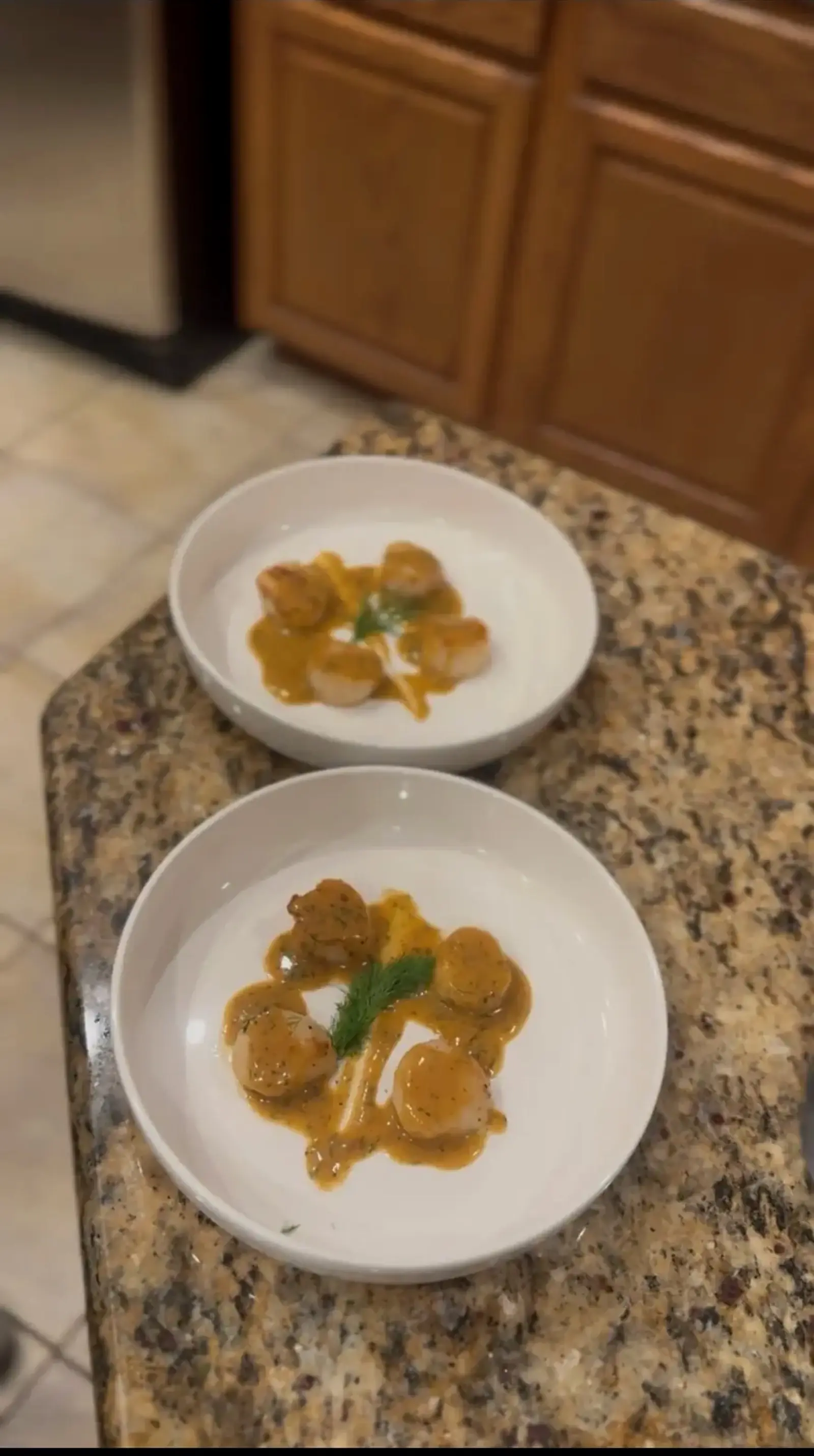 Seared scallops with sauce and fresh herbs